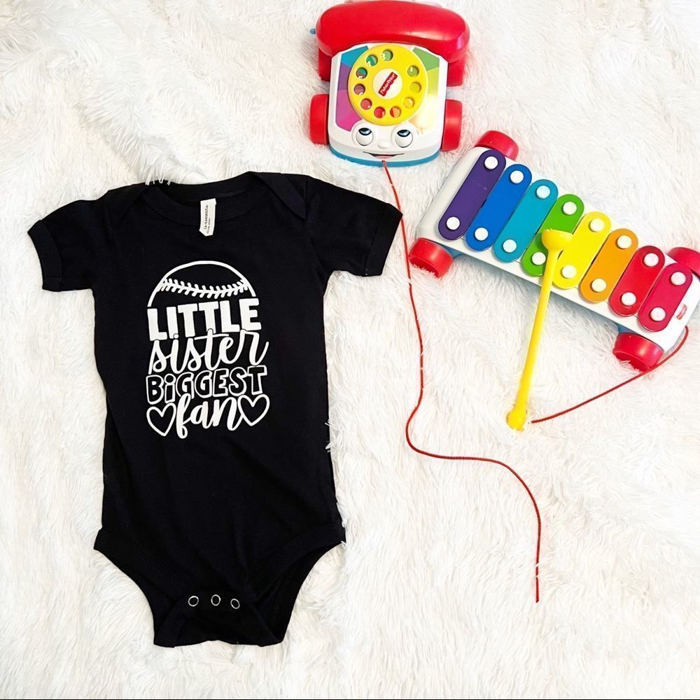Little sister Biggest Fan Bella Canvas Black 12-18mo Onesie
